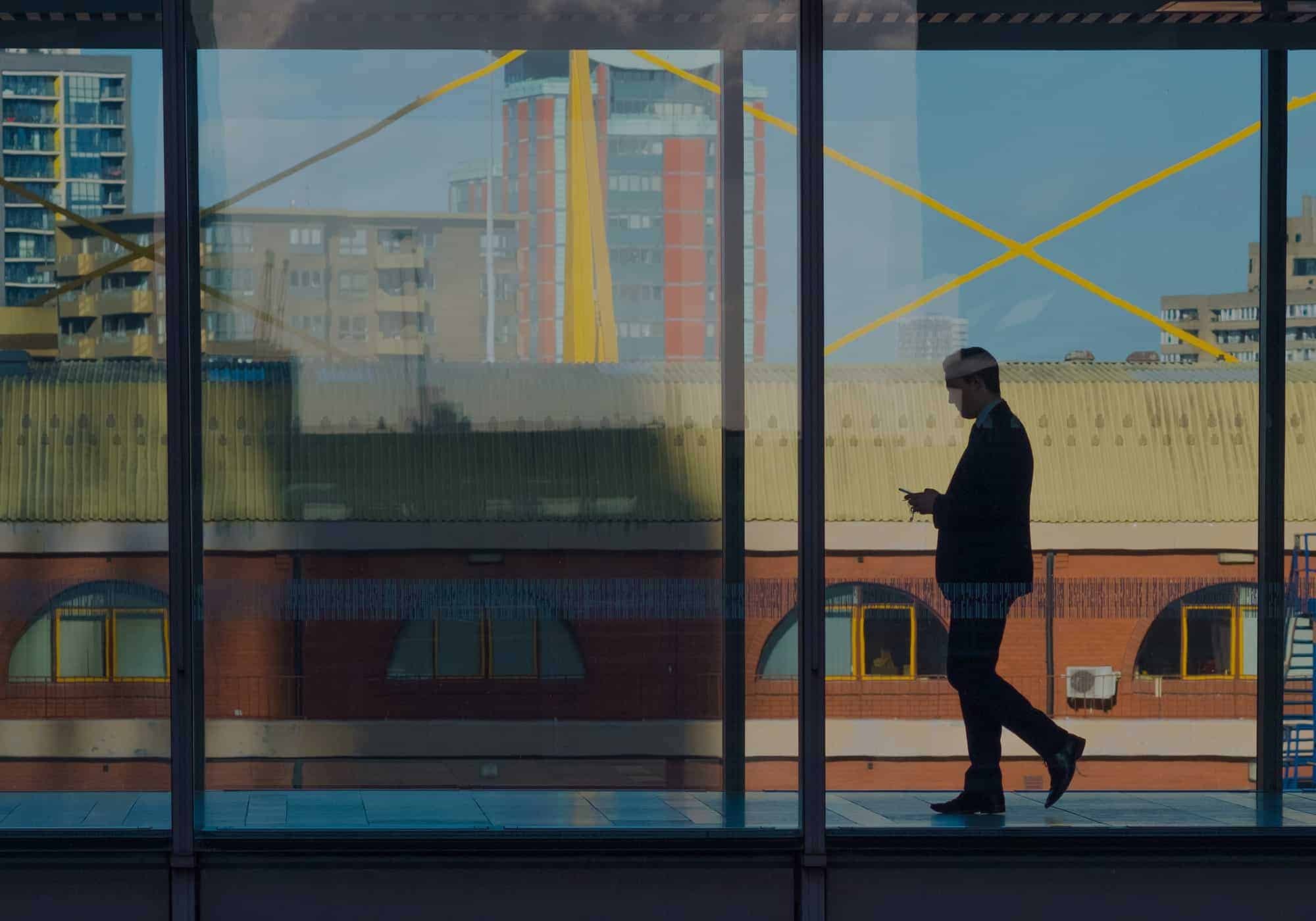 Silhouette dans une gare marchant un téléphone à la main